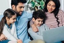 cheerful-hispanic-family-looking-at-laptop-at-home-2021-09-03-07-11-36-utc-Web