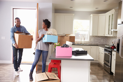 Couple Mvoing Boxes into New Apartment 